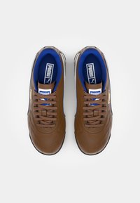 Καφέ δερμάτινα αθλητικά παπούτσια με μπλε επένδυση, διαθέτουν υφή, κορδόνια και χρυσό λογότυπο Puma στο πλάι. Ελαστική σόλα.