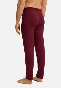Bordeauxkleurige jerseybroek met een ontspannen pasvorm, elastische tailleband en zijzakken. Vette textuur met een eenvoudig ontwerp.