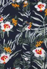 Navy knoop-overhemd met bloemenprint, voorzien van witte en rode bloemen, groene bladeren en oranje accenten. Machinaal genaaid met plastic knopen.