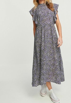 Maxi-jurk met bloemenprint in paars, met gerimpelde mouwen, een zoom tot op de knie en een losse pasvorm, gecombineerd met witte hoge sneakers.