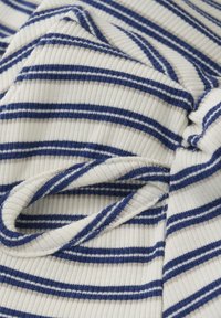 Bomullstyg med blå och ljusbruna horisontella ränder. Har en ribbad struktur med mjuka veck som visar dess flexibilitet.