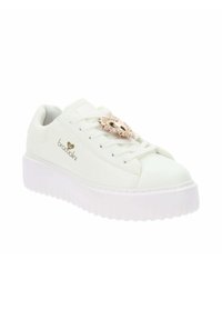 Zapatilla sintética blanca con suela de plataforma y un acento decorativo en color rose gold en los cordones. Presenta una textura suave y un logotipo de la marca.