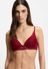 Burgundy pitsaa kolmio rintaliivissä on säädettävät hihnat, ja siinä on kuviollinen päällyste sekä teksturoitu vyö. Kevyt kangas hienolla yksityiskohdalla.