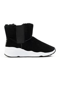 Botas de tobillo de ante negro con una suela de goma blanca texturizada, que presentan paneles elásticos para ponérselas fácilmente y un suave forro de piel en la parte superior.