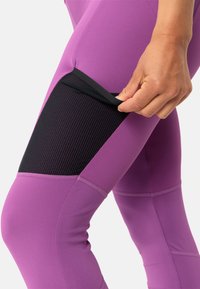 Lila Sportleggings verfügen über ein schwarzes Netzpanel auf dem Oberschenkel, flache Nähte und ein dehnbares Material für zusätzlichen Komfort.