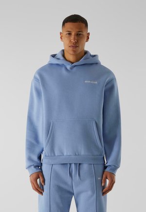 Lyseblå hoodie lavet af blød stof med en kengurulomme, ribbede manchetter og hætte med snorelukning. Har diskrete logodetaljer.