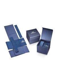 Embalaje de reloj de lujo de la marca Festina en color azul, mostrando caja desplegada plana, caja cerrada y caja abierta con compartimentos interiores.