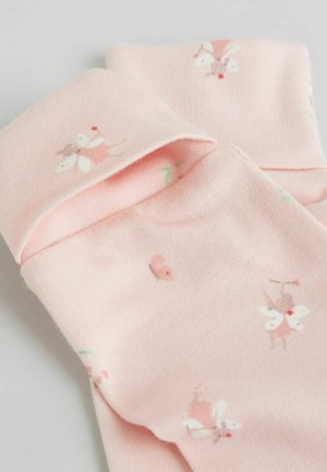 Svetloružové bavlnené ponožky s motívom víly a kvetov. Tkanina je mäkká s jemnou textúrou a na vrchu majú ohrnutý lem.