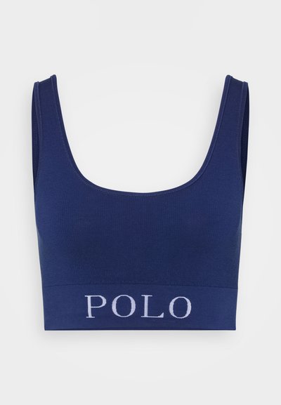 Marineblå ribbestrikket bralette med brede stropper og en tettsittende design. Har en kontrastfarge hvit "POLO"-logo på det elastiske båndet.