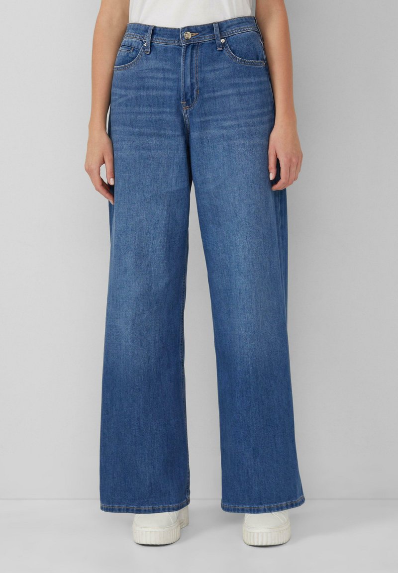 Široke jeans hlače iz medu prane denima. Imajo visok pas, sprednje žepe in klasično zapiranje na gumb. Struktura tkanine s podrobnostmi šivanja.