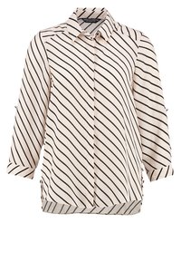 Blouse blanche à manches longues avec des rayures diagonales noires, boutonnée sur le devant et avec un col, présentée sur fond blanc.