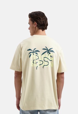 Lichtgele katoenen t-shirt met een achteropdruk van twee palmbomen en de tekst "HANG ELEVEN" in het groen, relaxte pasvorm, korte mouwen.