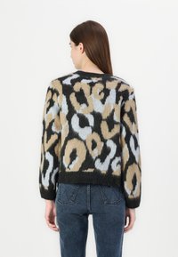 Fuzzy knit sweater featuring a leopard print in beige, black, and light blue. Wide sleeves and a rounded neckline, cropped design.