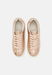 Glossy rose gold sneakers with textile upper, padded collar, six eyelets, and a white rubber sole. Lightly perforated design adds detail.