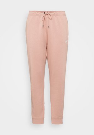 Lichtroze gebreide joggingbroek met elastische tailleband, trekkoord, omgeslagen enkels en klein wit Nike-logo op de linker dij.