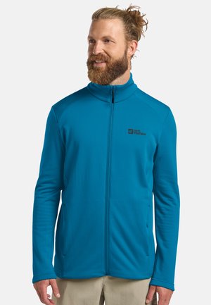 Blaue Fleecejacke mit hohem Kragen und vollem Reißverschluss. Verfügt über ein strukturiertes Muster, Seitentaschen und ein Logo auf der oberen Brust.