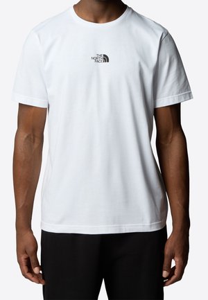 Biała koszulka z krótkim rękawem z małym czarnym logo The North Face na piersi, noszona przez osobę o ciemnej karnacji i czarnych spodniach.
