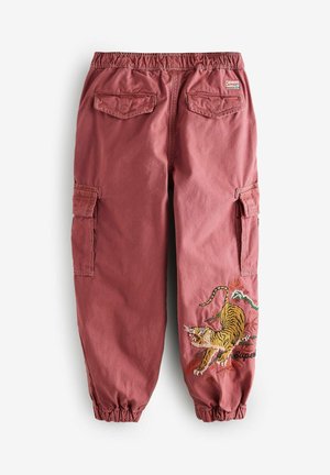 Spodnie cargo w kolorze rdzy z bawełny, z elastyczną talią, bocznymi kieszeniami oraz haftowanym wzorem tygrysa na prawej udzie.