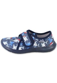Marinefarbene Slipper mit einem Obermaterial aus Stoff, das mit einem Haifischmuster versehen ist, Klettverschluss und flexibler Gummisohle. Strukturiere Oberfläche und verspieltes Design.