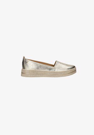 Chaussures slip-on en or métallique avec une semelle plate de style espadrille tissée, bout rond et surface texturée. Pas de matériel ou de motifs visibles.