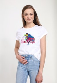 Bílý bavlněný tričko se svěžím grafickým designem postavy s nápisem "Doctor Strange" pod ním. Krátké rukávy, volný střih.