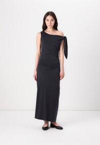 Asymmetrical black maxi dress in stretchy fabric, featuring a one-shoulder design with a tied accent and a fitted silhouette.