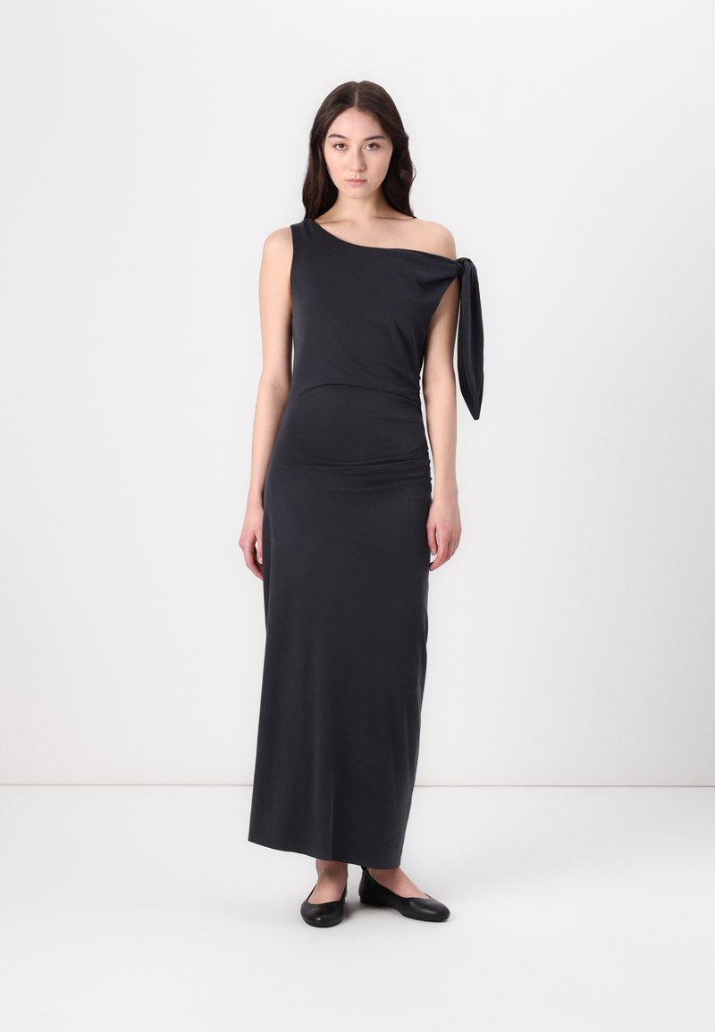 Asymmetrical black maxi dress in stretchy fabric, featuring a one-shoulder design with a tied accent and a fitted silhouette.