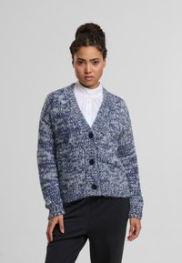 Blauw en wit gemarmerde cardigan met een diepe V-hals, vijfknops sluiting en een textured breiwerk. Heeft lange mouwen en een relaxte pasvorm.