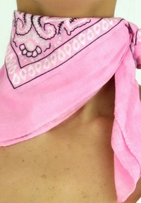 Foulard en bandeau rose en tissu léger, avec un motif cachemire et une bordure unie, noué lâchement autour du cou.