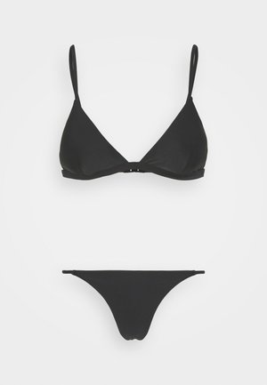 Biquíni preto com um top triangular e alças ajustáveis, de estilo minimalista. As partes de baixo são de corte baixo e simples.