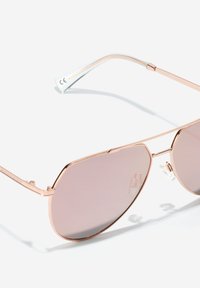Sluneční brýle ve stylu aviator z růžového zlata se gradientními růžovými skly, tenkým kovovým rámem a průhlednými stranicemi. Nastavitelné nosní podložky pro větší pohodlí.