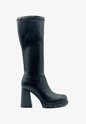 Botte noire à talon haut, arrivée au genou, en matériau synthétique lisse. Elle présente un talon épais et texturé ainsi qu'une conception de bout arrondi avec des détails de couture latérale.