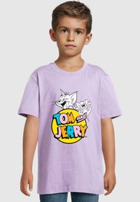 Fialové bavlněné tričko s krátkým rukávem s grafickým potiskem Toma a Jerryho nad textem "TOM a JERRY" v tučném, mnohobarevném písmu.