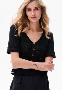 Czarny krótki dzianinowy top z krótkim rękawem i dekoltem w kształcie litery V, z teksturowanym wzorem, drewnianymi guzikami oraz lekko skróconym krojem.