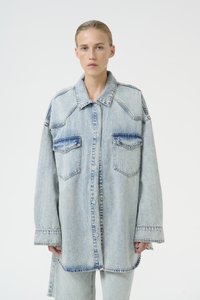 Giacca camicia oversized in denim azzurro chiaro con due tasche frontali, colletto appuntito e dettagli di cucitura a vista. Texture liscia.