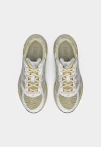 Ανδρικά αθλητικά παπούτσια με διάτρητο ύφασμα σε ανοιχτό κίτρινο και λευκό χρώμα. Διαθέτουν δέσιμο με κορδόνια, αναπαυτικό πάτο και εξωτερική σόλα από καουτσούκ.