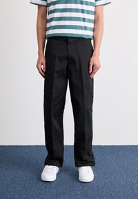 Black pants with a straight-leg design, featuring a smooth texture and clean lines, paired with a horizontally striped teal and white shirt.