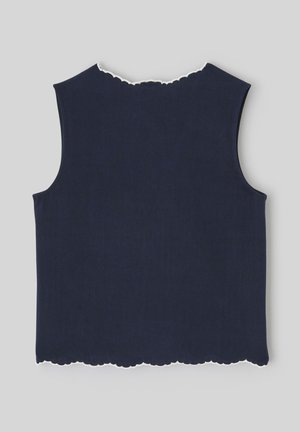 Haut sans manches en maille bleu marine avec bordure blanche festonnée au niveau de l'encolure et de l'ourlet, posé à plat sur un fond gris clair.