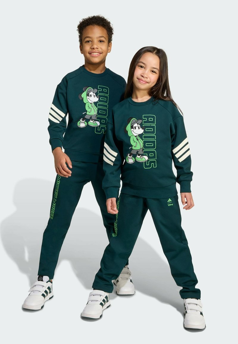 Dark green sweatshirt and pants featuring white stripes and a cartoon character print. Sweatshirt has raglan sleeves; pants have side text detail.