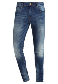 Jeans ajustados de denim azul oscuro con un lavado descolorido. Las características incluyen cinco bolsillos y un cierre de botón en la cintura.