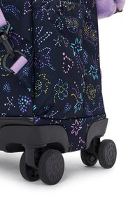 Rollkoffer aus einem dunkelblauen Stoff, der mit bunten floralen Mustern bedeckt ist. Ausgestattet mit schwarzen Rädern und einem lila Tragegurt. Strukturierte Oberfläche.