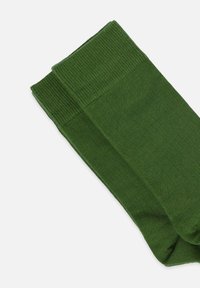 Dunkelgrüne Socken aus einem glatten, dehnbaren Strickmaterial mit einem gerippten Bündchen, das ein nahtloses Design für mehr Komfort bietet.