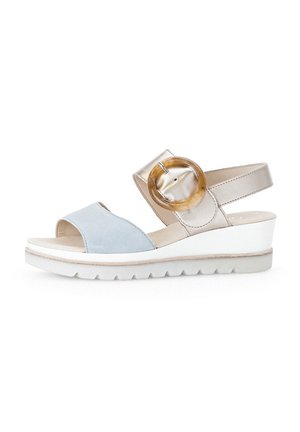 Wedge sandal with a light blue suede front, metallic gold accents, large circular buckle, and white textured sole.