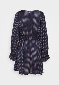 Marinblå klänning med långa ärmar, samlad midja och volangpåverkade manschetter. Har ett litet rosa blommönster och en nyckelhålsöppning bak med knapp.