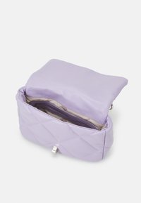 Quiltet lavendel håndtaske med en glat finish, sølvhardware og en indvendig lynlås lomme. Åbner til en blød, lysfarvet foring.