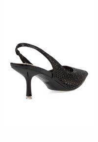 Tacones de slingback negros con punta afilada, que presentan una parte superior texturizada y perforada y un tacón delgado y brillante. Acabados con un capuchón metálico en el tacón.