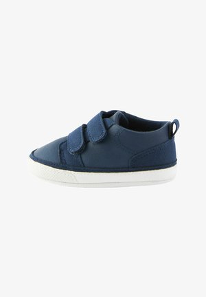 Scarpa in pelle blu navy con due cinturini in velcro, suola in gomma bianca e finitura testurizzata, caratterizzata da cuciture decorative e un certificato nel retro.