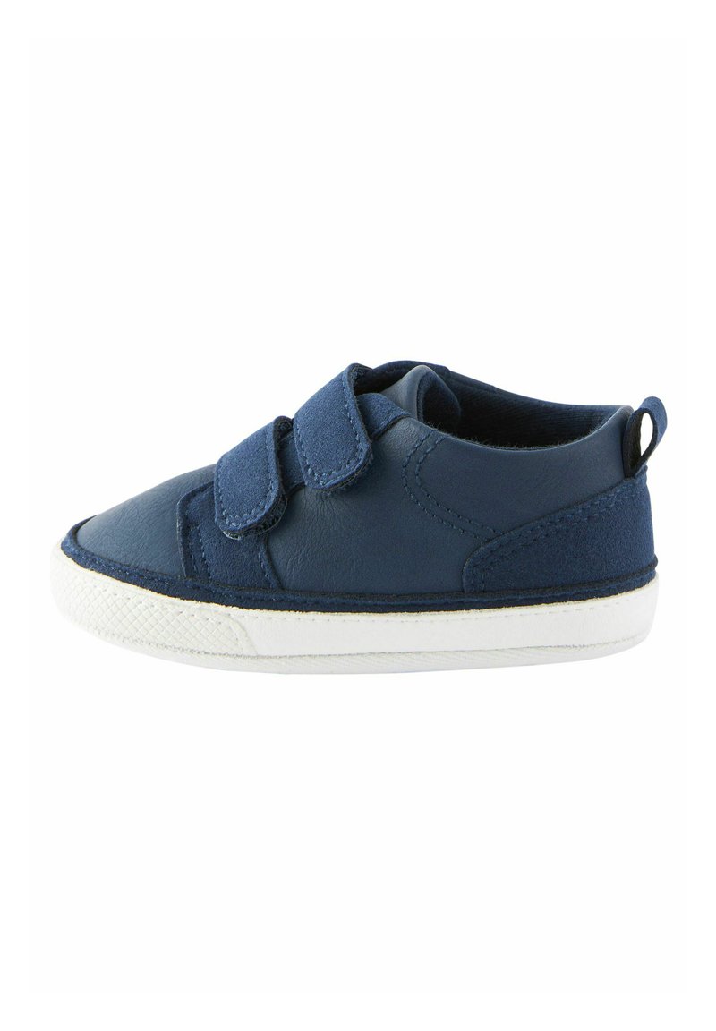 Chaussure en cuir bleu marine avec deux bandes auto-agrippantes, semelle en caoutchouc blanche et finition texturée, présentant des accents de couture et une languette au dos.