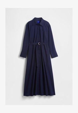 Granatowa sukienka z długim rękawem, z paskiem w talii, kołnierzykiem, miękkim materiałem, zapięciem na guziki z przodu oraz pojedynczą kieszonką na piersi.