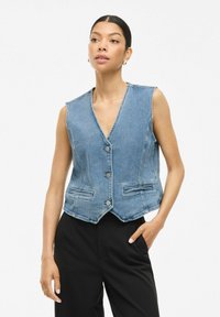 Denim prsluk svijetloplave boje, bez rukava s V-izrezom, s pet metalnih dugmadi, dva prednja džepa i skraćenim rubom.